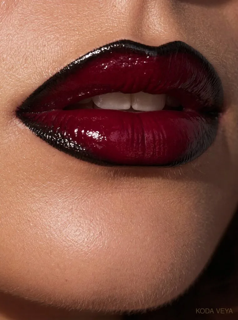 Close-up of a two-tone burgundy lip, almost black at the edges and glossy cherry-wine in the centre