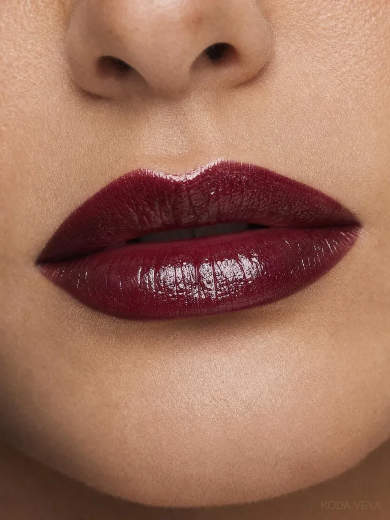 Close-up of a glossy black cherry burgundy lipstick